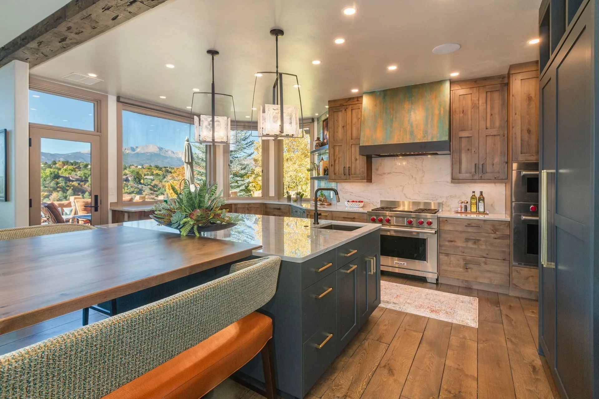 Plush Designs kitchen with knotty alder cabinetry, a verdigris hood and a window looking out toward the mountains