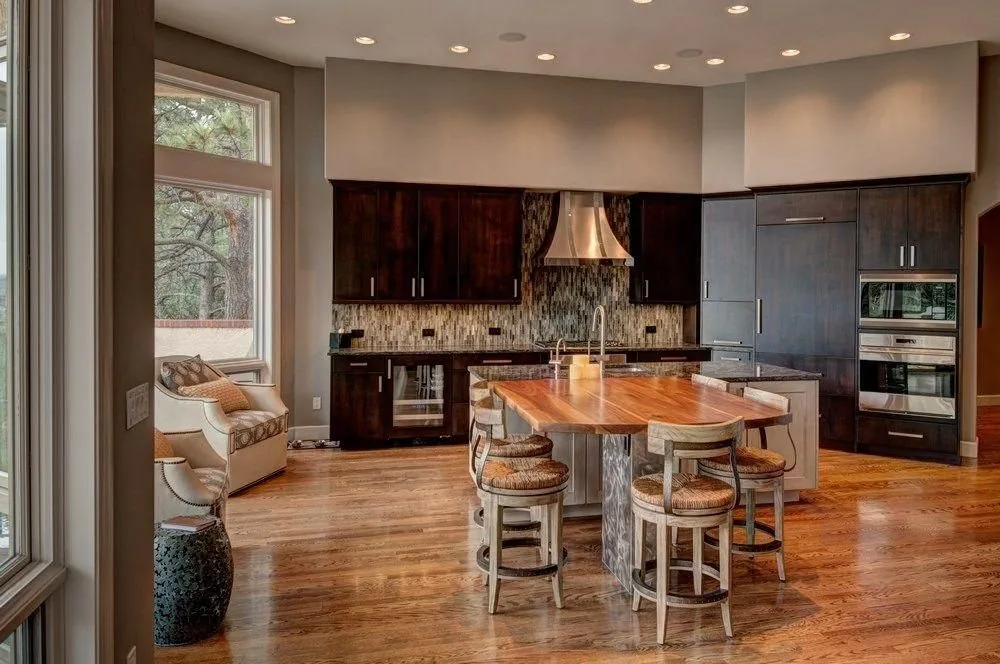 A remodeled Plush Designs kitchen with dark wood cabinetry and an open dining area
