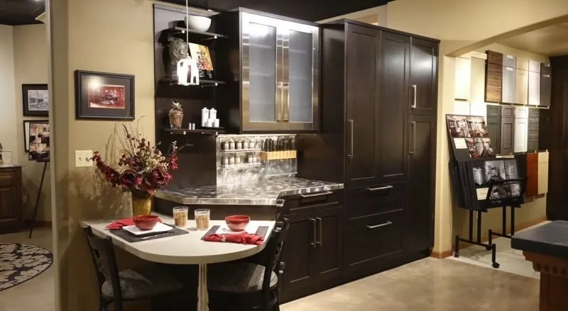 A display vignette in the Plush Designs showroom with dark cabinetry and a set table
