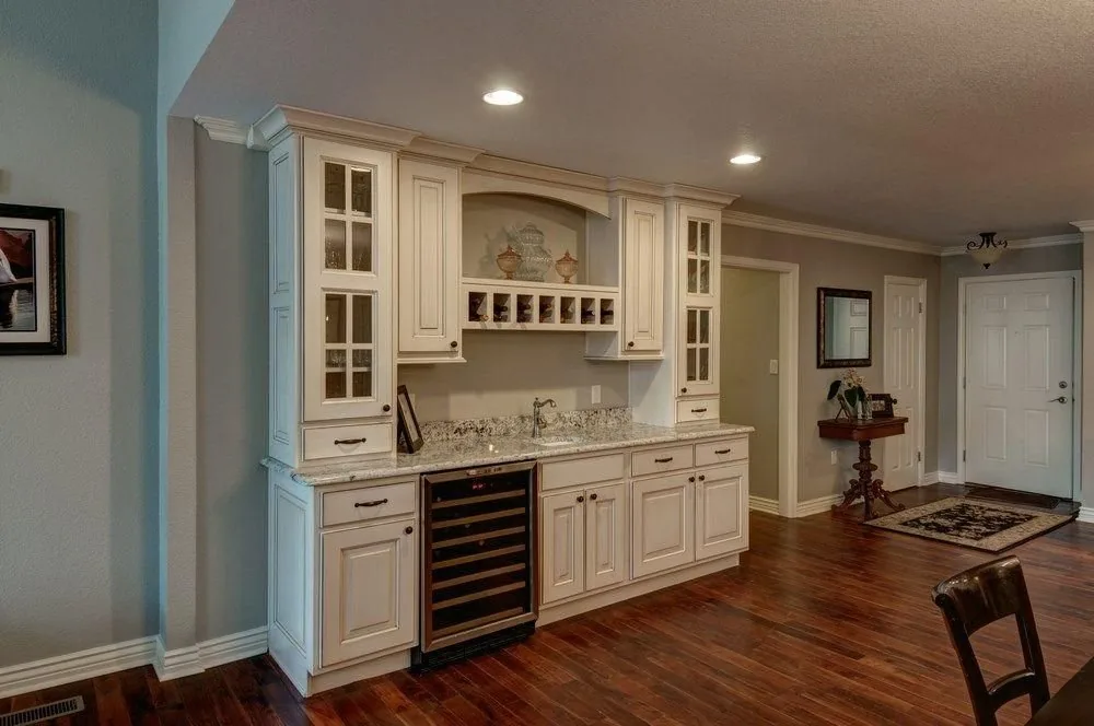 Home bar by Plush Designs, with glass-front upper cabinets and built-in wine storage
