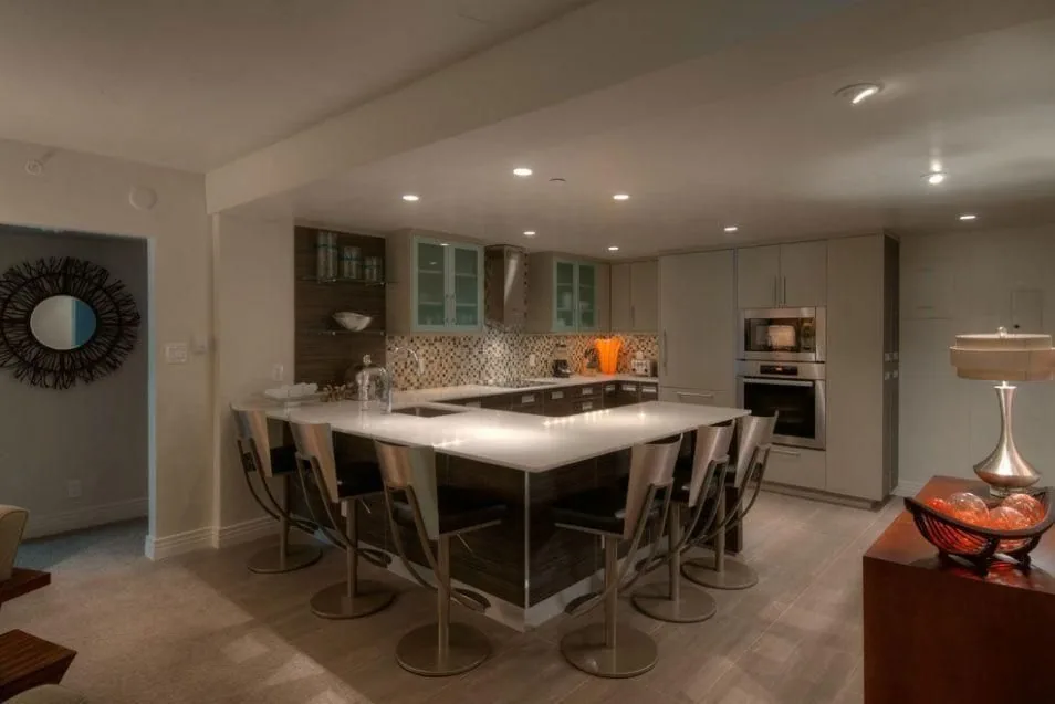 Vail project by Plush Designs, a room lined with built-in wood shelving and windows